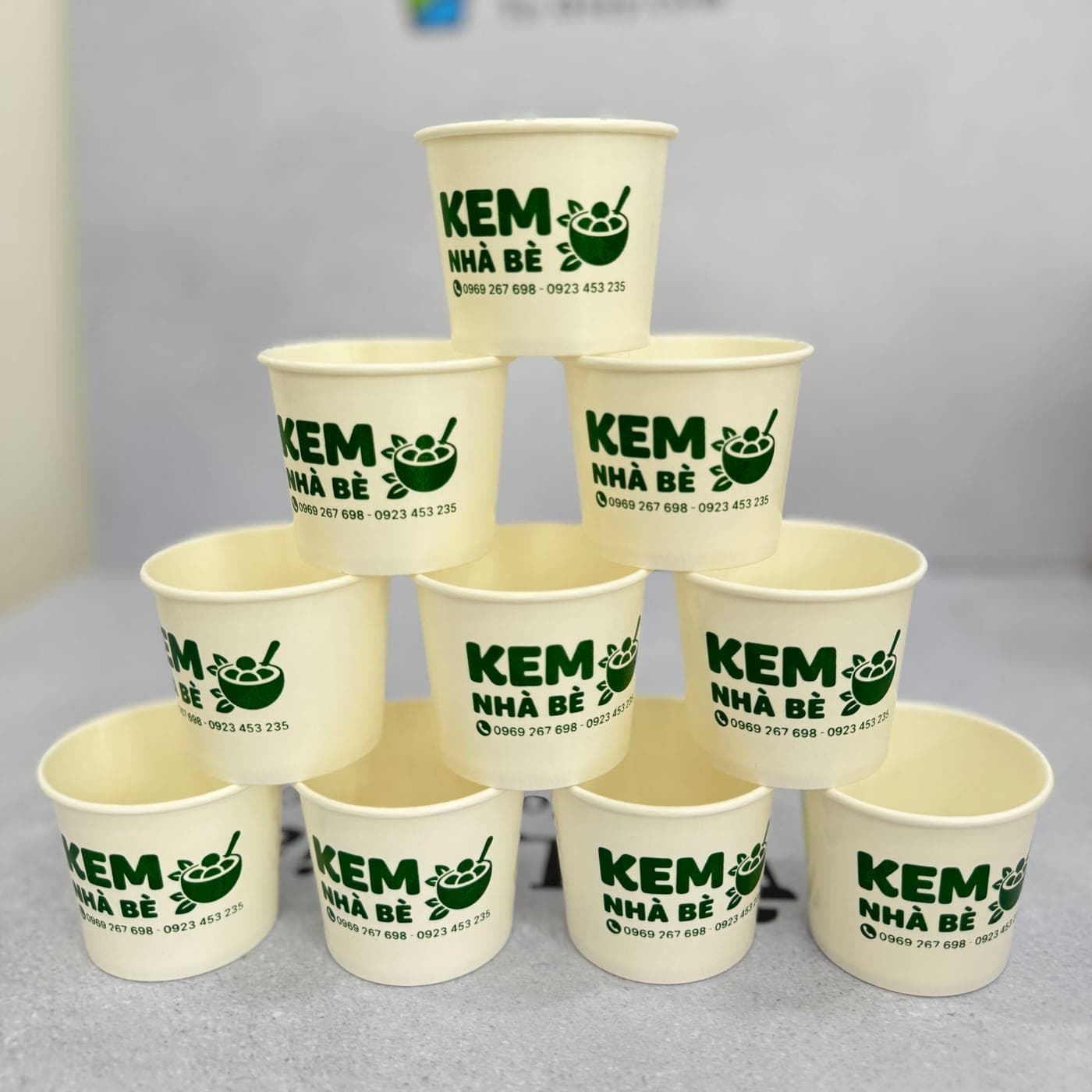 4 oz single wall paper cups printed with a green ice-cream shop logo, stacked in a pyramid